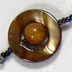 Gold Saturn composed of tigerseye and mother of pearl elements